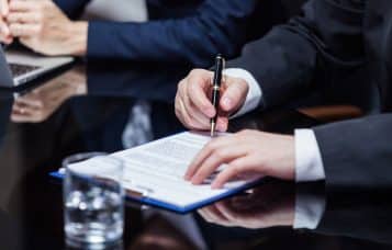 a man in a suit signing a document