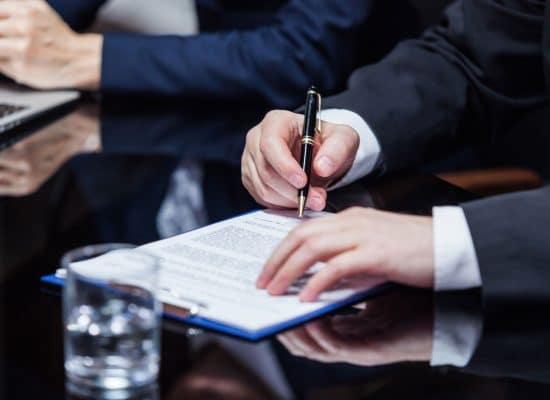 a man in a suit signing a document