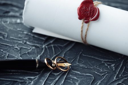 a wax sealed letter with a fountain pen beside it