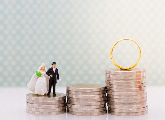 a toy of a man and woman in wedding outfit on top of coins