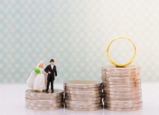 a toy of a man and woman in wedding outfit on top of coins