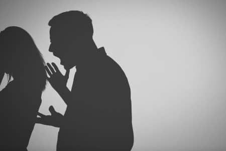 a silhouette of a man shouting to a woman