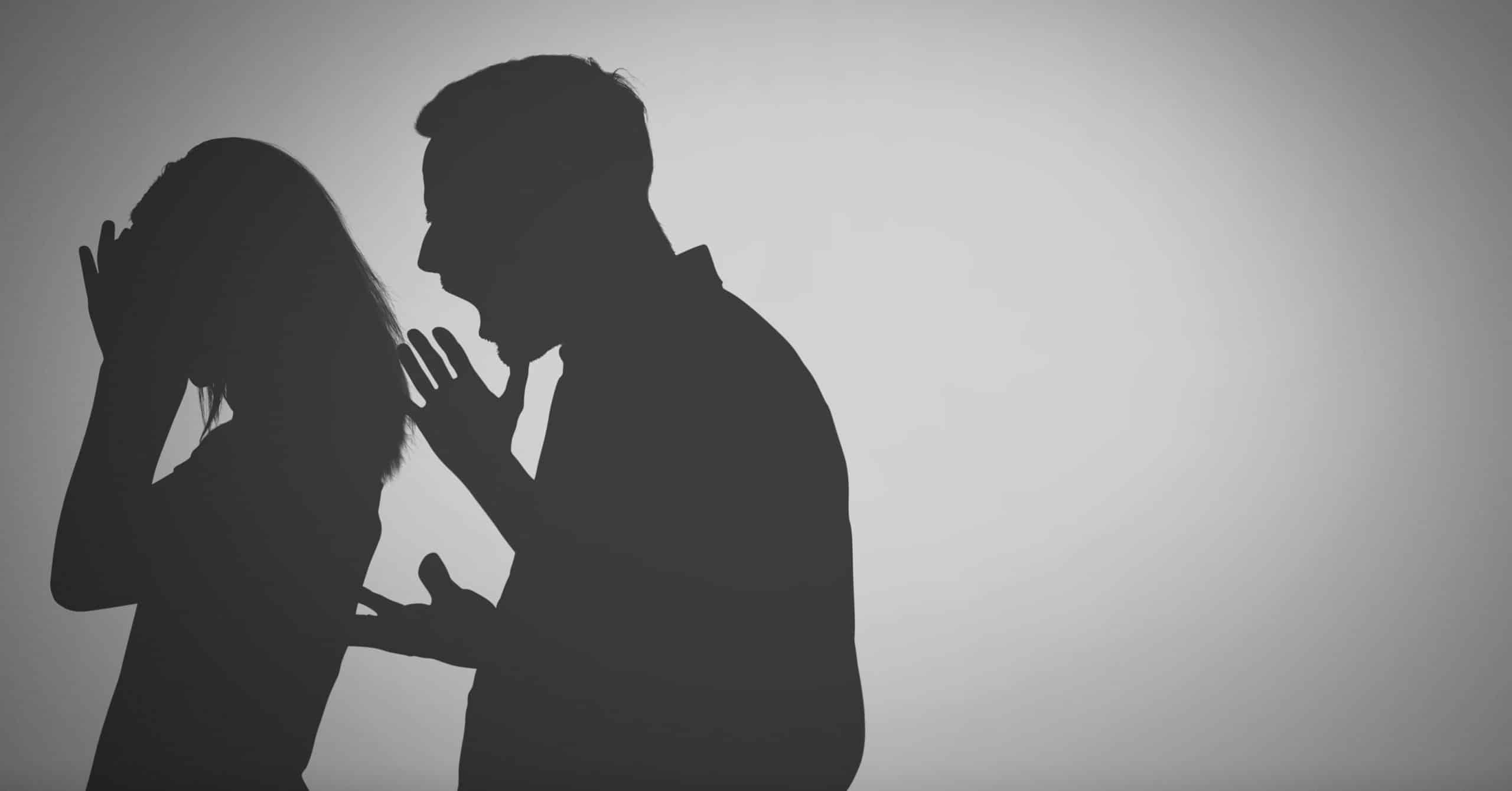 a silhouette of a man shouting to a woman